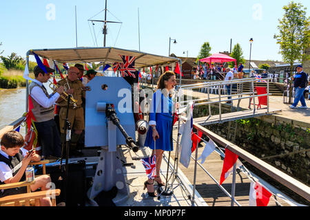Salut à la 40s populaire événement nostalgique. La victoire de guerre groupe jouant sur pont de bateau, avec des profils femme chantant et agitant le drapeau Union Jack. Banque D'Images