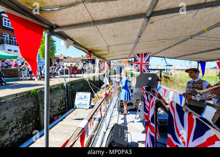 Salut à la 40s populaire événement nostalgique en Angleterre. La victoire de la bande de guerre et une femme sur scène chanteuse pont de bateau avec l'Union jack drapeaux. Banque D'Images