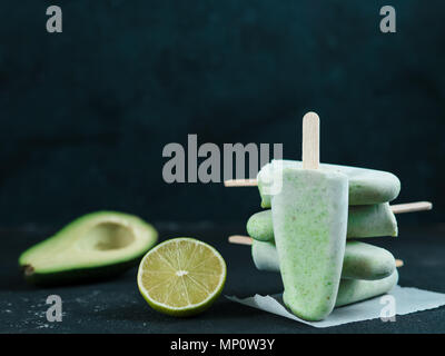 Végétalien premières maison lime avocat ma glace. Sans sucre, sans produits laitiers, crème glace verte sur fond texturé noir. Copier l'espace. Des idées et des recettes pour une collation, dessert ou boisson fouettée Banque D'Images