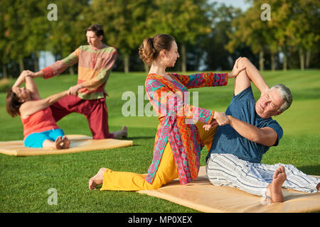 Les personnes faisant des exercices de yoga en plein air. Banque D'Images