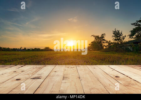 Table en bois vide haut et l'affichage du champ de fond flou avec montage au coucher du soleil. Banque D'Images