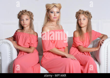 Mère de deux adorables jumelles dans de belles robes rose Banque D'Images