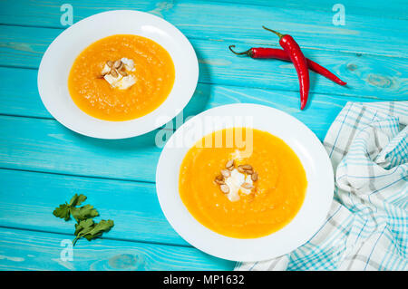 Deux portions de soupe de potiron sur un fond en bois bleu. Banque D'Images