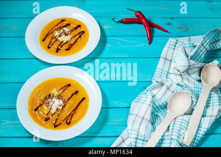 Deux portions de soupe de potiron sur un fond en bois bleu. Banque D'Images