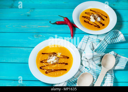 Deux portions de soupe de potiron sur un fond en bois bleu. Banque D'Images