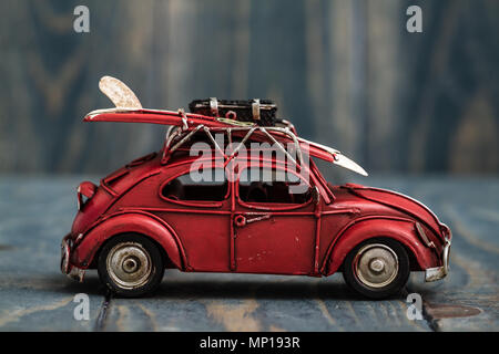 Mini classique modèle de voiture rouge sur bleu fond de bois Banque D'Images