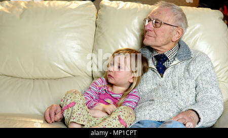 Grand-père et ses 3 ans petite-fille regarder la télévision ensemble Banque D'Images