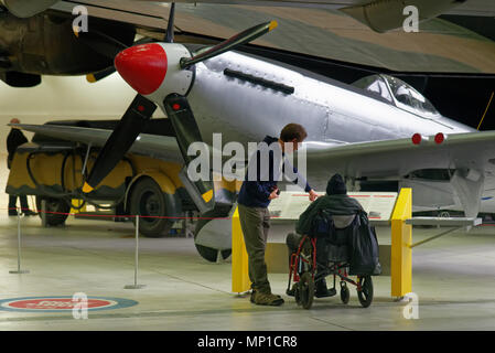 Un homme en fauteuil roulant à la recherche au Spitfire Mk 24 dans le Musée de l'air de Duxford Cambridgeshire, Angleterre, Banque D'Images