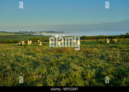 Merry Maidens Stone Circle tôt le dimanche 20 mai 2018, la brume flotte dans l'air comme les premiers rayons de soleil éclairent les pierres et bâtiments agricoles éloignées Banque D'Images