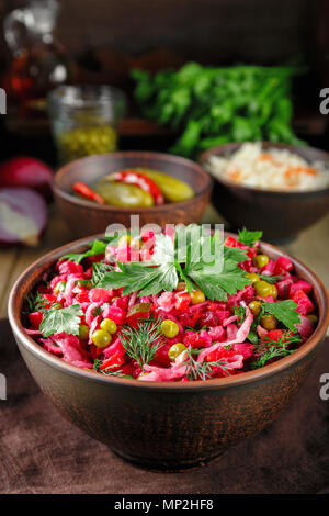 Vinaigrette salade avec des légumes bouillis, concombres, choucroute et pois verts en conserve dans une cuvette d'argile. Snack traditionnel russe. Fo végétarien Banque D'Images