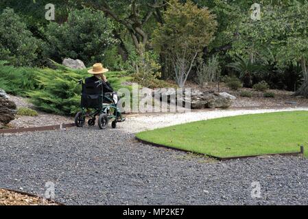 Personne en fauteuil roulant à parc en ville australienne de Coffs Harbour. Seul l'homme en fauteuil roulant. Notion de personne seule Banque D'Images