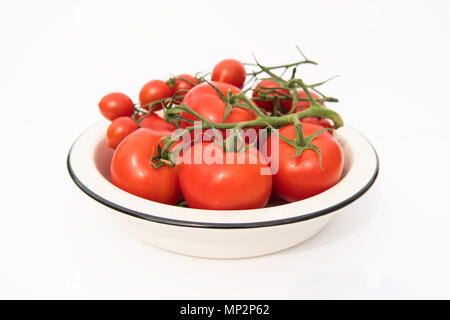 Les tomates de vigne rouge dans un bol blanc Banque D'Images