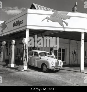 Années 1950, historique, un accompagnateur à Mobilgas service station nettoie le pare-brise d'une automobile, Londres, Angleterre, Royaume-Uni. Banque D'Images