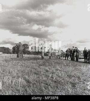 Années 1960, le pays à l'extérieur sur les terres agricoles messieurs prenant part à un concours de tir au pigeon d'argile, Buckinghamshire, Angleterre, Royaume-Uni. Banque D'Images