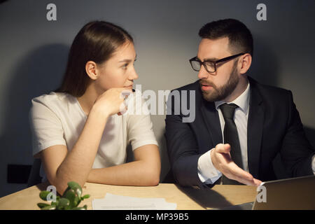 Travailleur homme expliquant quelque chose à collègue Banque D'Images