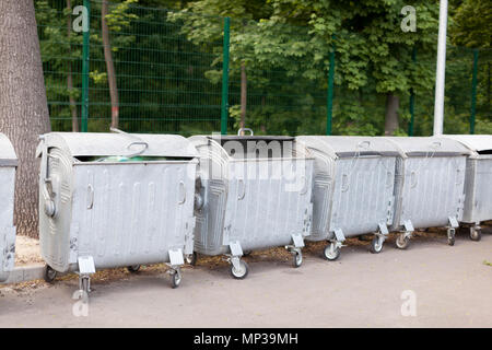 Grand métal rempli des poubelles sur la rue standing in a row Banque D'Images