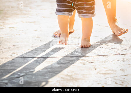 Mère et Bébé pieds prend des mesures à l'extérieur. Banque D'Images