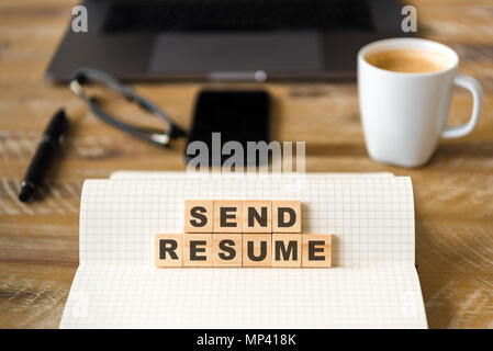 Gros plan sur ordinateur portable sur la table de bois, l'arrière-plan l'accent sur des pièces en bois avec des lettres faisant Envoyer texte du CV. Concept d'image. Banque D'Images