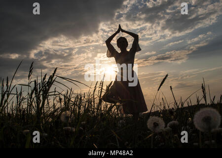 Yoga et danse rituelle du rendement par le coucher du soleil Banque D'Images