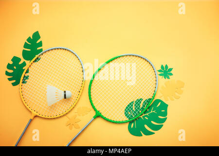 Badminton beach set. Activités d'été de mise à plat avec les feuilles sur un fond jaune lumineux avec copie espace. Banque D'Images