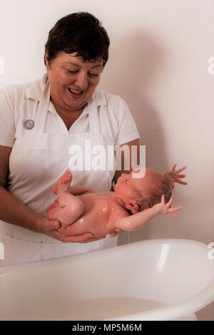 Bebe Garcon Surpris Dans Une Situation De Peur De Surprise En Jetant Ses Bras En Arriere Quand L Infirmiere De La Maternite Le Place Pour Se Baigner Photo Stock Alamy