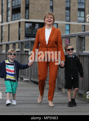 Premier ministre Nicola Sturgeon avec Brody Downs (à gauche) et Jack McGeady de Bridgeton Famille visitant la Cuningar Loop à Glasgow où elle a révélé de nouveaux investissements pour le programme de régénération de la passerelle de Clyde. Banque D'Images