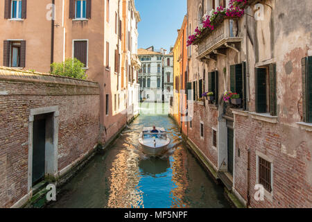 Un petit bateau s'approche de la caméra sur un canal à Venise Banque D'Images