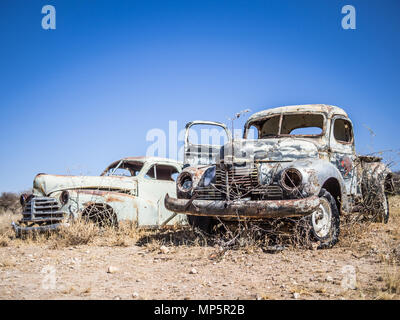 La rouille des voitures classiques abandonnés dans le désert de Namib, Namibie Banque D'Images