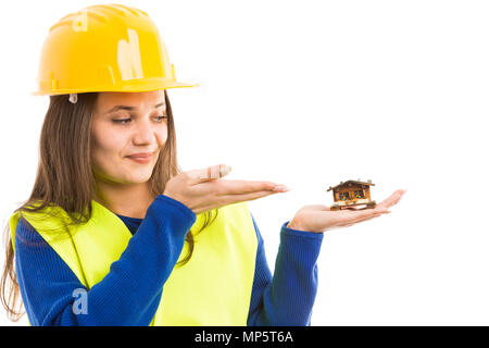 Jeune femme ingénieur ou architecte holding petite maison et faire le geste de présentation de concept de l'offre immobilière isolé sur fond blanc Banque D'Images