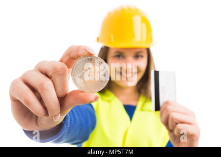 Jeune femme ingénieur ou architecte holding silver symbole bitcoin et carte de crédit comme cryptocurrency paiement numérique isolé sur fond blanc Banque D'Images