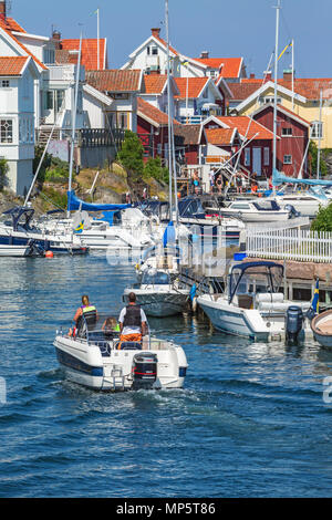 Bateaux entrant dans l'étroit canal de la mer entre les bateaux et maisons Banque D'Images