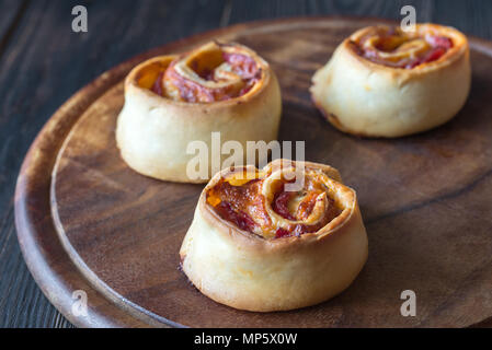 Rouleaux de pizza sur la planche de bois Banque D'Images