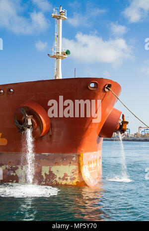 Pompage de pétroliers comme l'eau de ballast de navires remorqueurs sur quai dans les guides port Banque D'Images