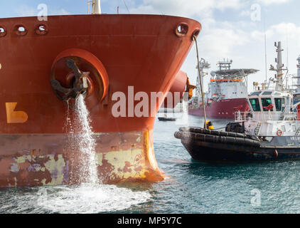 Pompage de pétroliers comme l'eau de ballast de navires remorqueurs sur quai dans les guides port Banque D'Images