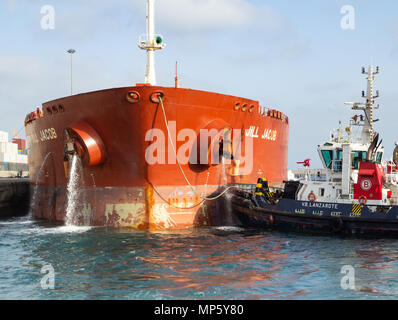 Pompage de pétroliers comme l'eau de ballast de navires remorqueurs sur quai dans les guides port Banque D'Images