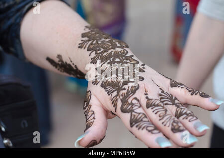 L'art et la diversité. Un gros plan d'une femme avec la main de conception, mehndi appliquée par un artiste à l'henné Shilparamam arts & crafts village, Hyderabad, Inde. Banque D'Images