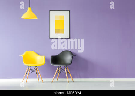 Vue avant de couleur contrastante, jaune et noir des chaises et une lampe jaune fond violet contre mur avec une affiche dans un minimum d'inter de salon Banque D'Images