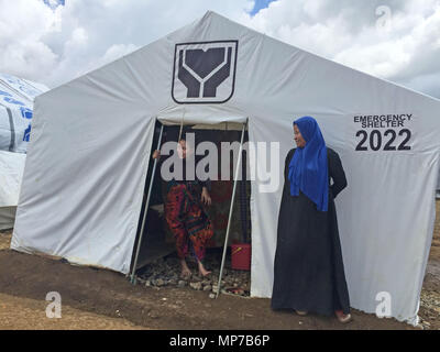 07 mai 2018, Philippines, Marawi : Fatima Lumabao (à droite), 49 ans, résident de Marawi City, et l'une de ses fille, Aracma Lumabao - 20, qui n'a pas vu quatre de ses huit enfants depuis le début des combats à Marawi City l'année dernière, se penche sur l'une de ses filles à l'extérieur de leur tente dans un abri temporaire à Marawi City site. Photo : Girlie Linao/dpa Banque D'Images