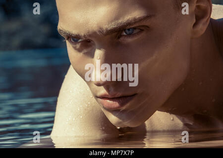 Portrait masculin dans l'eau de mer bleu clair Banque D'Images