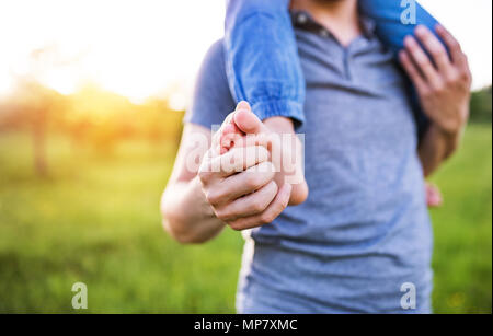 Petite fille un père donnant piggyback ride au printemps la nature. Banque D'Images