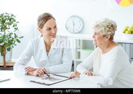 Femme en surpoids consulting avec happy nutritionniste en uniforme blanc dans la clinique Banque D'Images