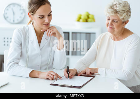 Diététicienne et patient diabétique avec ruban mesurer quotidiennement discuter alimentation saine à l'hôpital Banque D'Images