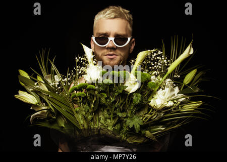 Avec l'homme élégant bouquet de fleurs blanches sur fond noir Banque D'Images