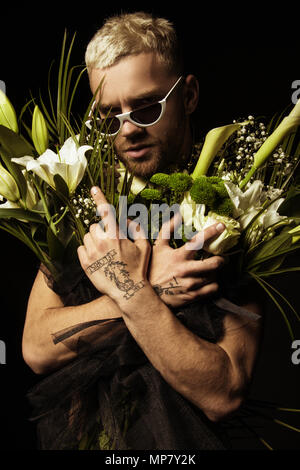 Avec l'homme élégant bouquet de fleurs blanches sur fond noir Banque D'Images