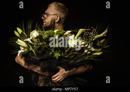 Avec l'homme élégant bouquet de fleurs blanches sur fond noir Banque D'Images