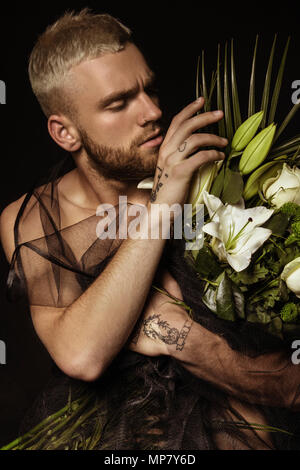 Avec l'homme élégant bouquet de fleurs blanches sur fond noir Banque D'Images