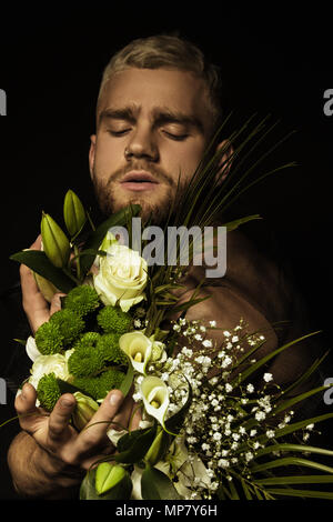 Avec l'homme élégant bouquet de fleurs blanches sur fond noir Banque D'Images