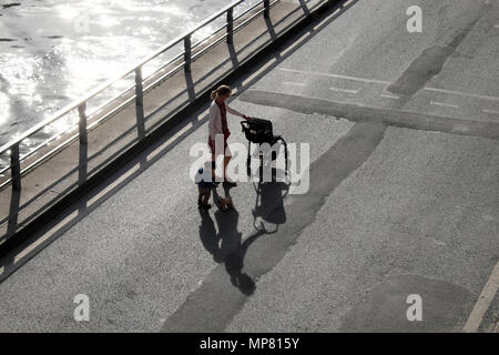 Vue d'en haut à en bas de femme avec enfant et poussette jouet chien chiot avec ombre et marcher le long de la Seine à Paris France KATHY DEWITT Banque D'Images