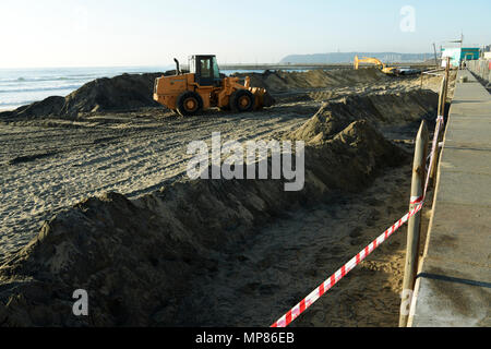 Durban, le KwaZulu-Natal, Afrique du Sud, bande de sécurité le long mur de soutènement, excavation jaune sable plage de mise à niveau du tracteur sur la promenade Banque D'Images