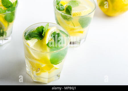 La limonade maison avec les tranches de citron et de menthe fraîche sur tableau blanc Banque D'Images